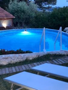 马丁纳弗兰卡Villa Messerà的夜晚的游泳池,有蓝色的水