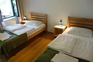 梅斯蒂亚山景旅馆的配有两张床铺的房间,桌子上放着两盏灯