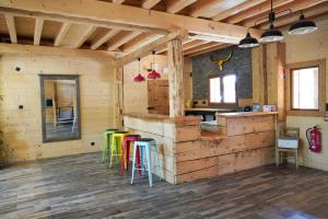 贝尔内La Ferme De L'âne Rouge 7 nuits minimum的小木屋内的厨房配有色彩缤纷的凳子