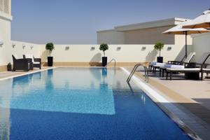 迪拜Avani Deira Dubai Hotel的建筑物屋顶上的游泳池