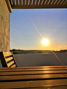 特里皮蒂Haroto Suites的阳台的长凳,享有日落美景