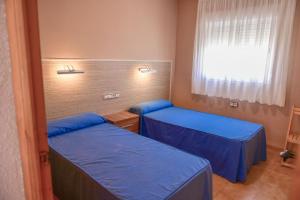 托雷夫兰卡TEPINSA · Alquiler de Apartamentos的客房设有两张床和窗户。