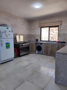 阿杰隆Furnished house بيت مفروش ابو فارس的厨房配有白色冰箱和窗户。