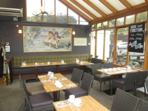 Lasswade领主与狗旅馆的用餐室设有木桌、椅子和窗户。