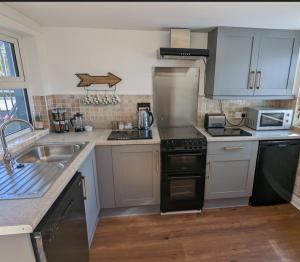 库申多尔Antrim Coast Apartments的厨房配有水槽和炉灶 顶部烤箱