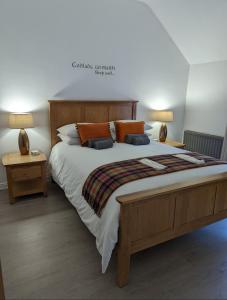 库申多尔Antrim Coast Apartments的一间卧室配有一张大床和两盏灯