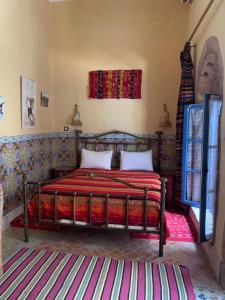 萨菲里亚德乐奇法尔酒店的一间卧室配有一张红色床罩的床