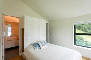 蓬塔德尔加达Sete Cidades Lake Cabin - Casa da Lagoa的白色的卧室设有床和窗户