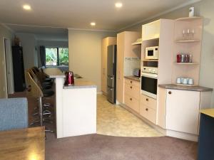 帕拉帕拉乌姆海滩Observation Holiday Home的厨房配有白色橱柜和台面