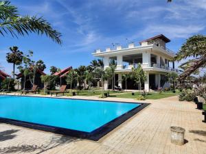 尼拉瓦利Anukama Resort的一座大房子,前面设有一个游泳池