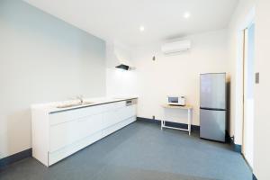 志摩市the circle apartment的厨房配有白色橱柜和冰箱。