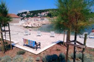 弗班吉Holiday house with a swimming pool Vrbanj, Hvar - 11040的坐在沙滩上水边的长凳