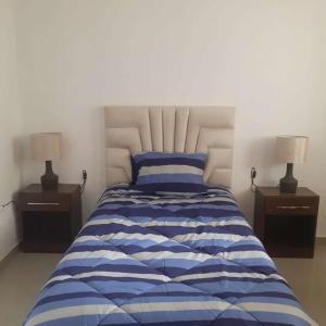 卡哈马卡Casa-Posada的一间卧室配有一张带两盏灯的蓝色和白色的床。