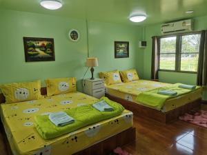 北碧布萨拉库姆度假酒店的绿墙客房内的两张床