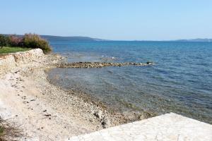 苏科尚Apartments by the sea Sukosan, Zadar - 12313的一片岩石海岸,一片大片的水域