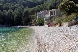 博格莫耶Secluded fisherman's cottage Cove Smokvina, Hvar - 13608的河岸边的岩石海滩,有房子