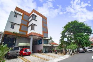 雅加达Uptown Residence Syariah Pondok Pinang的前面有一辆红色汽车的建筑
