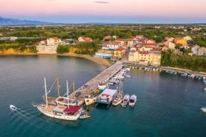 普利拉卡Apartments by the sea Privlaka, Zadar - 15288的享有码头的空中景色,在水中划船