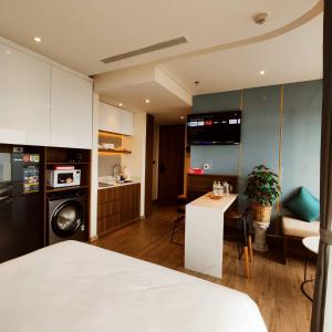 绥和市IVORY Apartment Apec Phu Yen with POOL Access的一间带一张床的房间和一间带桌子的厨房