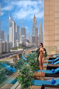 迪拜迪拜费尔蒙特酒店的一位在一座城市建筑屋顶上行走的女人