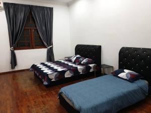 汝来Nilai Spring Villas的一间卧室设有两张床和窗户。