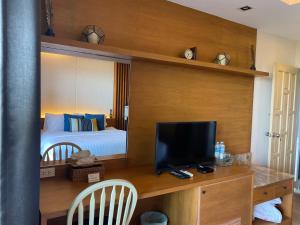 查龙Phuket View Coffee and Resort的一间卧室配有一张床和一张书桌及电视