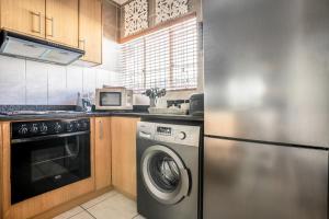 斯泰伦博斯Avemore Wag n Bietjie No 1的厨房配有洗衣机和微波炉。