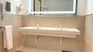 迪拜SITARA HOTEL APARTMENT的浴室设有白色水槽和镜子