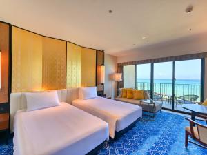 糸满琉球名城海滩度假酒店的酒店客房设有两张床和一个阳台。