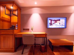 仰光Prince Hotel的客房设有书桌和墙上的电视。
