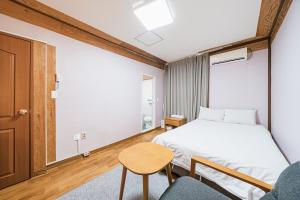 济州市Jeju Miju Hotel的卧室配有1张床、1张桌子和1把椅子