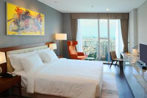 胡志明市Sedona Suites Ho Chi Minh City的卧室设有白色的床和大窗户