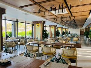 Cam LâmMystery Villas & Spa Cam Ranh的餐厅设有木桌、椅子和窗户。