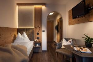 瓦尔道拉Almhotel Lenz的酒店客房配有一张床铺和一张桌子。