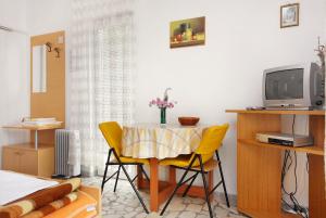 塞尔瑟Studio Selce 4801a的一间带桌子和黄色椅子的用餐室