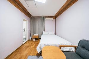 济州市Jeju Miju Hotel的一间卧室配有一张床、一张沙发和一把椅子