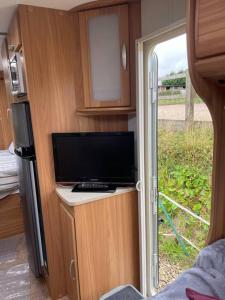 哈利法克斯Inviting 4 Berth caravan in Hebden Bridge的电视转角和滑动玻璃门