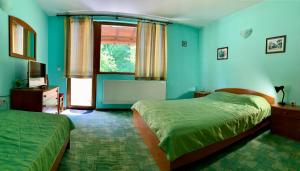 特里亚夫纳新阁旅馆的一间蓝色卧室,配有两张床和窗户