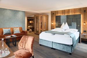 塞尔瓦迪加尔代纳山谷Hotel Comploj Adults only的一间卧室配有一张大床和一张沙发