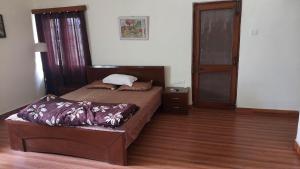德拉敦vera home stay的一间卧室设有两张床,铺有木地板