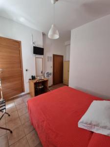 菲纳莱利古雷里兹酒店 的一间卧室配有红色的床和电视