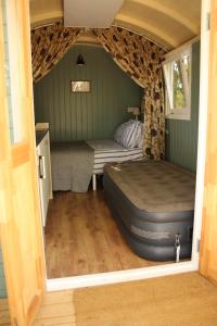 斯托马基特The Kestrel Shepherd Hut, Whitehouse Farm的一间卧室配有一张床和一个沙发
