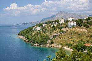 泰斯Apartments by the sea Nemira, Omis - 4277的水边小山上的一个村庄