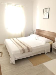 KozaricaApartments by the sea Kozarica, Mljet - 4950的白色的卧室设有一张大床和一个窗户
