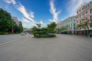 下龙湾De Charm Hạ Long Hotel的城市里一条空荡荡的街道,汽车驶向这条街道