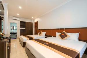 下龙湾De Charm Hạ Long Hotel的酒店客房带两张床和一间浴室