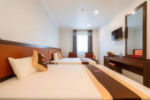 下龙湾De Charm Hạ Long Hotel的酒店客房配有两张床和一张书桌