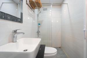 下龙湾De Charm Hạ Long Hotel的一间带水槽、卫生间和淋浴的浴室