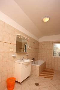 拉布Apartments with a parking space Kampor, Rab - 5018的浴室配有盥洗盆和浴缸。