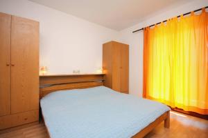拉布Apartments and rooms by the sea Palit, Rab - 5044的一间卧室配有床和黄色窗帘